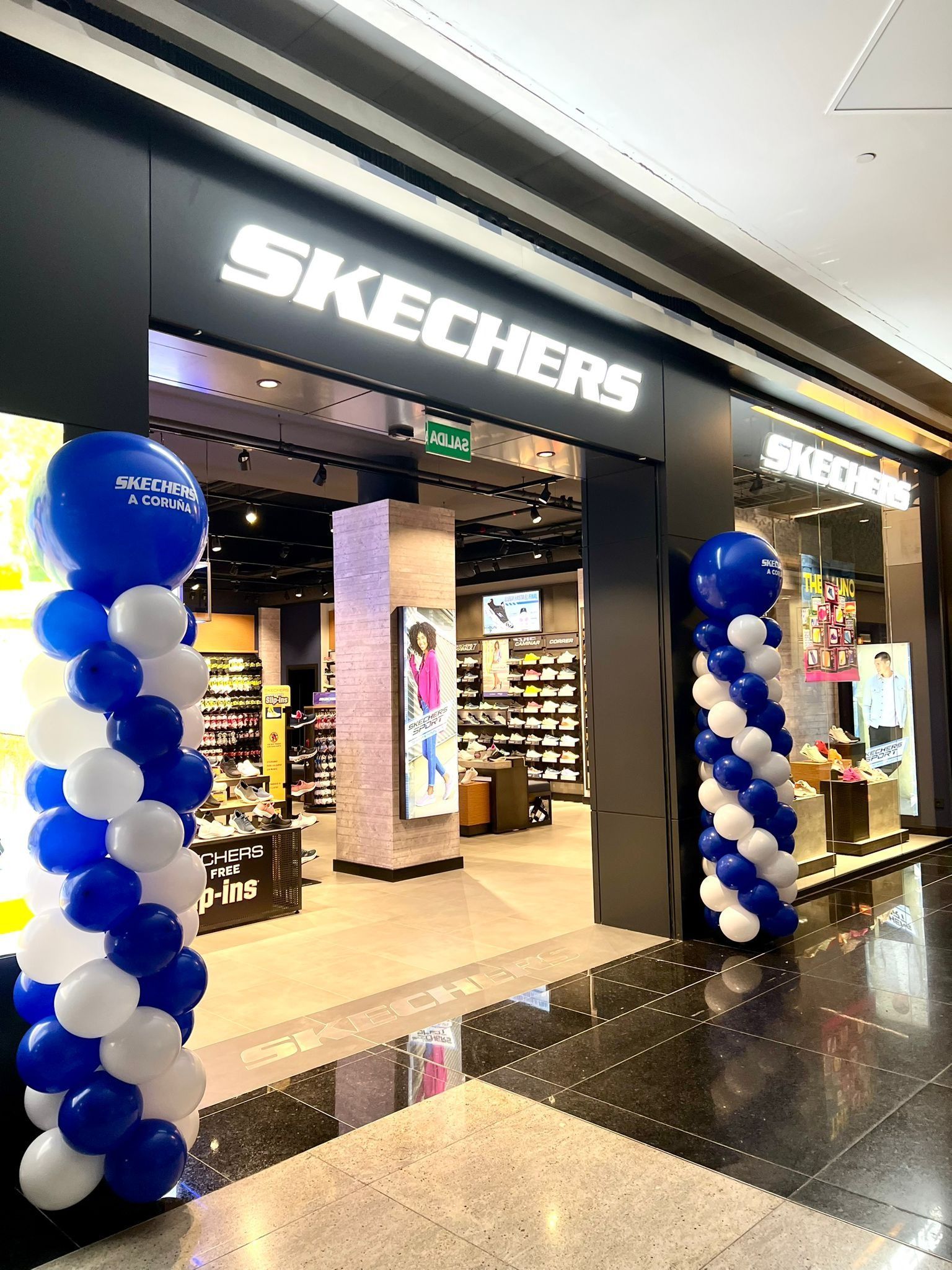Una tienda Skechers está decorada con globos azules y blancos.