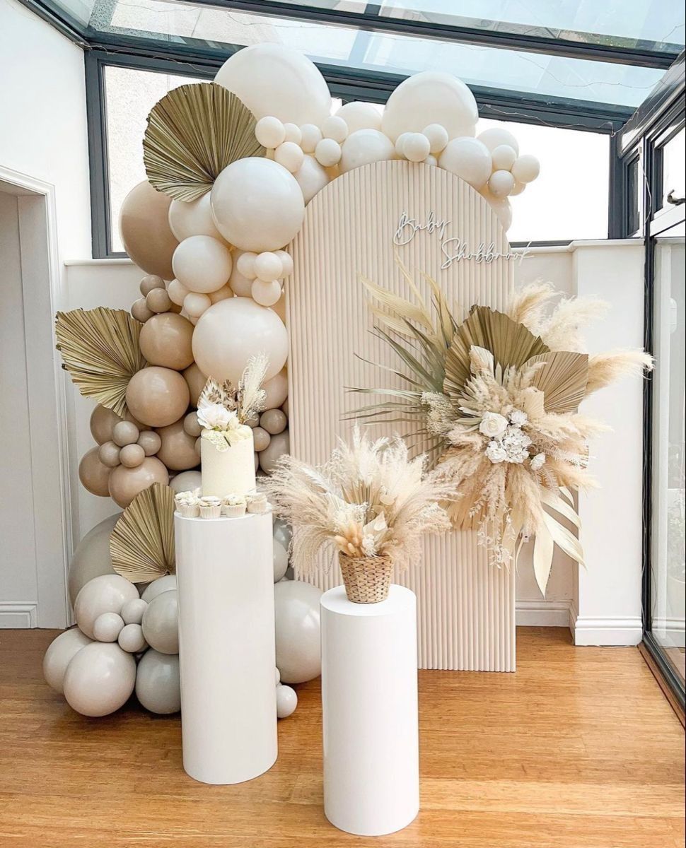 Una habitación decorada con globos, flores y un pastel.