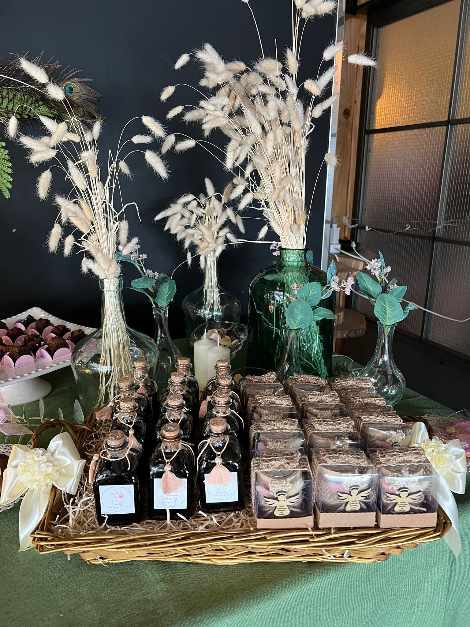 Una mesa con una bandeja de botellas y flores encima.