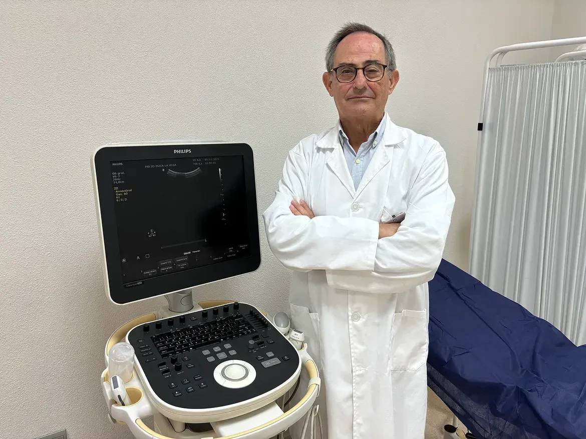 Un médico está de pie delante de una máquina de ultrasonido.