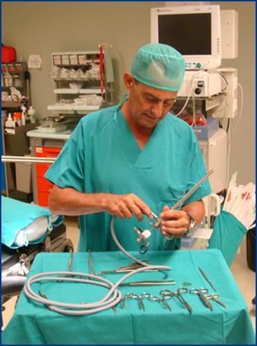 Un cirujano en un quirófano sostiene un par de tijeras.