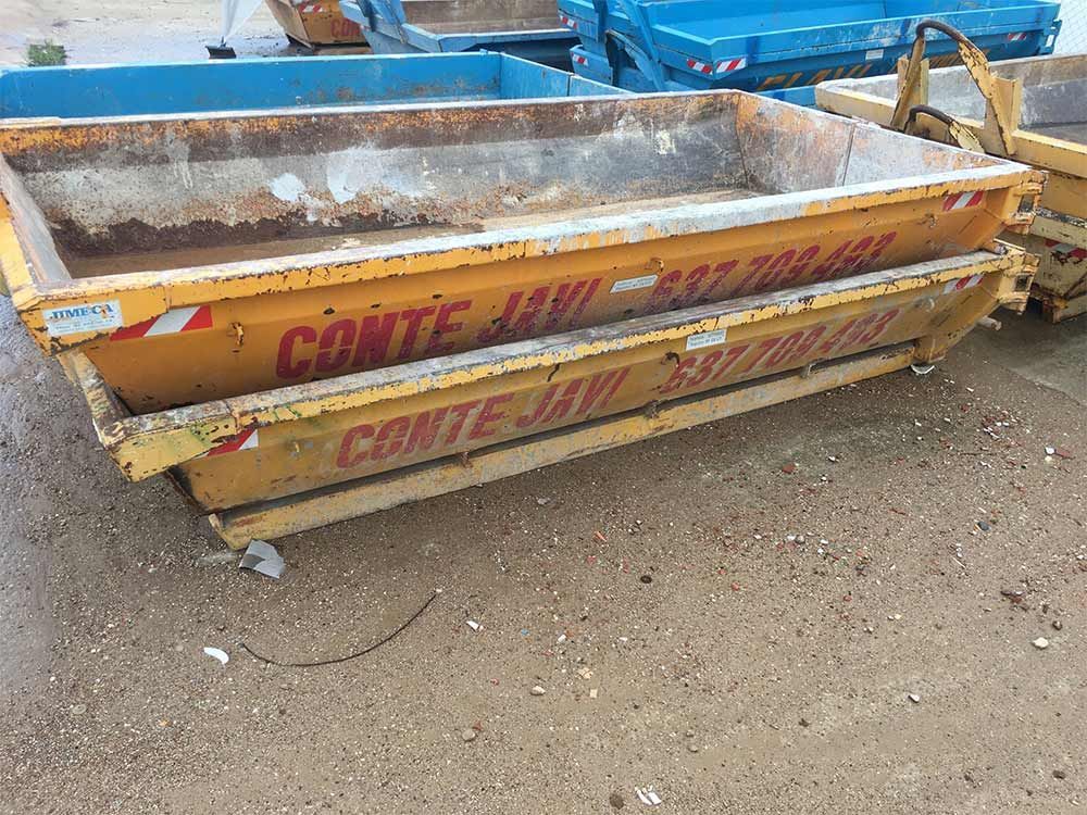 Dos contenedores amarillos de Conte Javi apilados al aire libre.