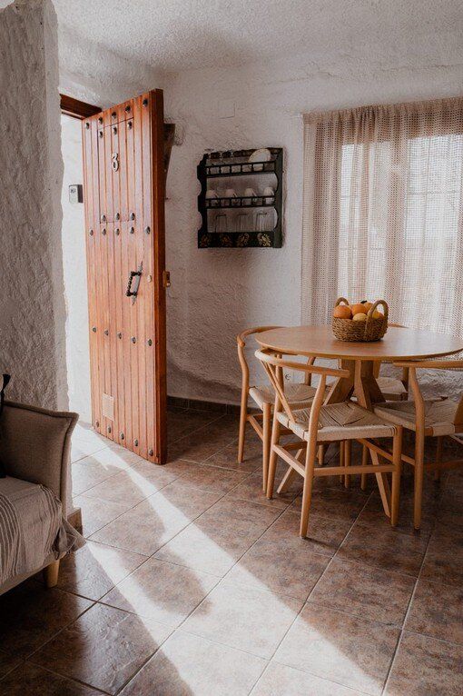 Un comedor con mesa y sillas y una puerta de madera.