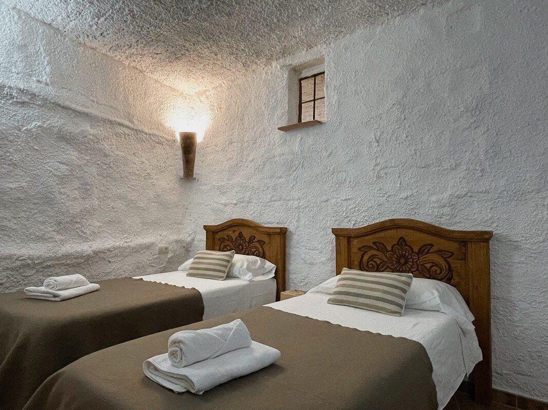 Un dormitorio con dos camas individuales y una ventana.