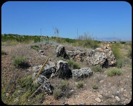 Un paisaje de rocas y césped con un cielo azul de fondo.