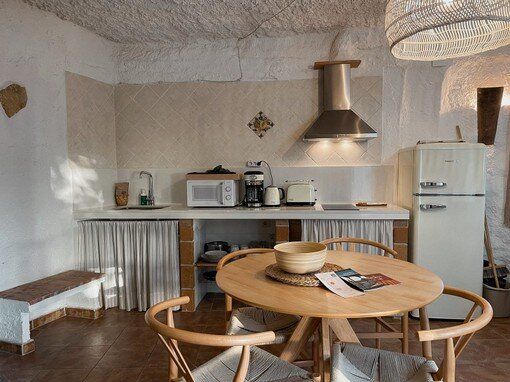 Una cocina con mesa y sillas y un frigorífico.