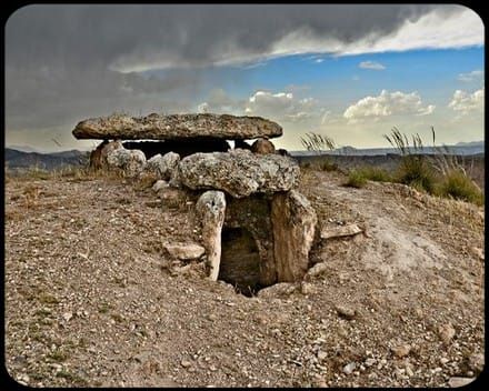 Una gran roca en medio de un campo de tierra
