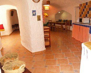 Una sala de estar con mesa y sillas y una cocina.