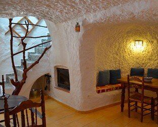 Un comedor con mesa y sillas en una cueva.