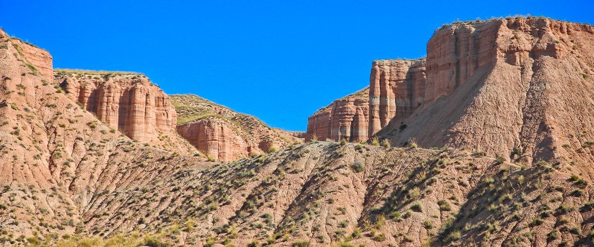 Una vista de un cañón con un cielo azul al fondo.