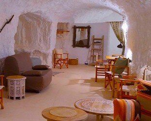 Una sala de estar con un sofá, sillas, mesas y un espejo.