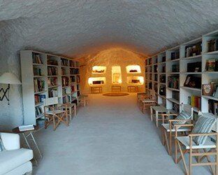 Una habitación con muchas estanterías y sillas.