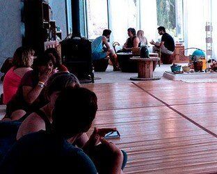 Un grupo de personas está sentada en el suelo de una habitación.