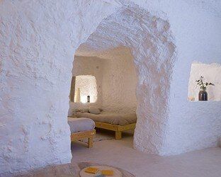 Un dormitorio en una cueva con una cama y una ventana.