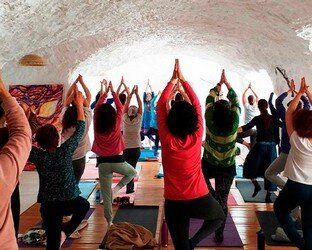 Un grupo de personas está haciendo yoga en una cueva.