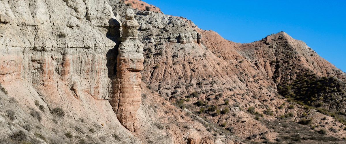 Un primer plano de una montaña con un cielo azul en el fondo.