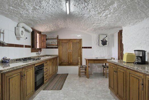 Una cocina con gabinetes de madera y encimeras de granito.