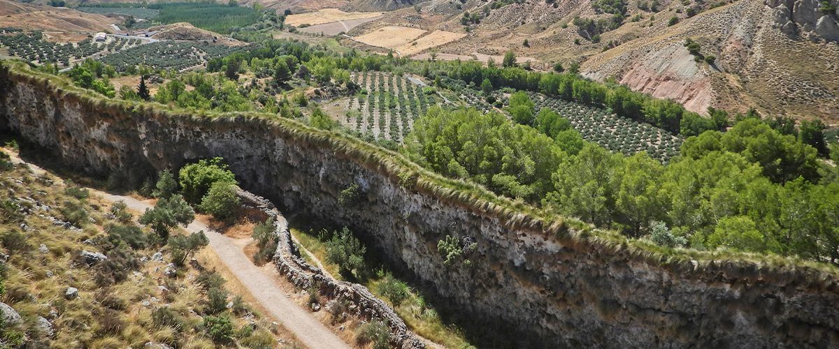 Una vista aérea de un valle rodeado de montañas y árboles.