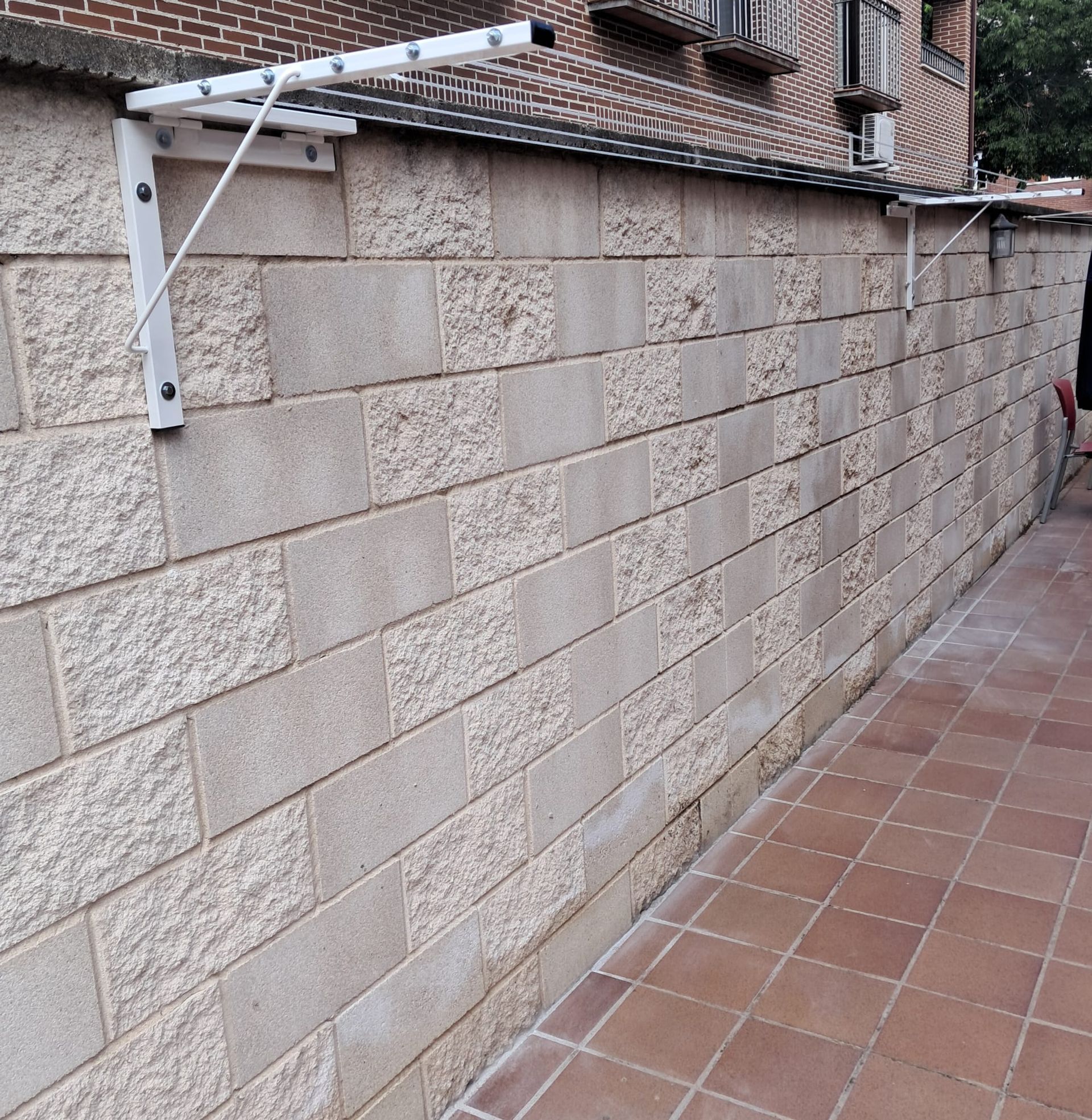 Una pared de ladrillos con un tendedero pegado a ella