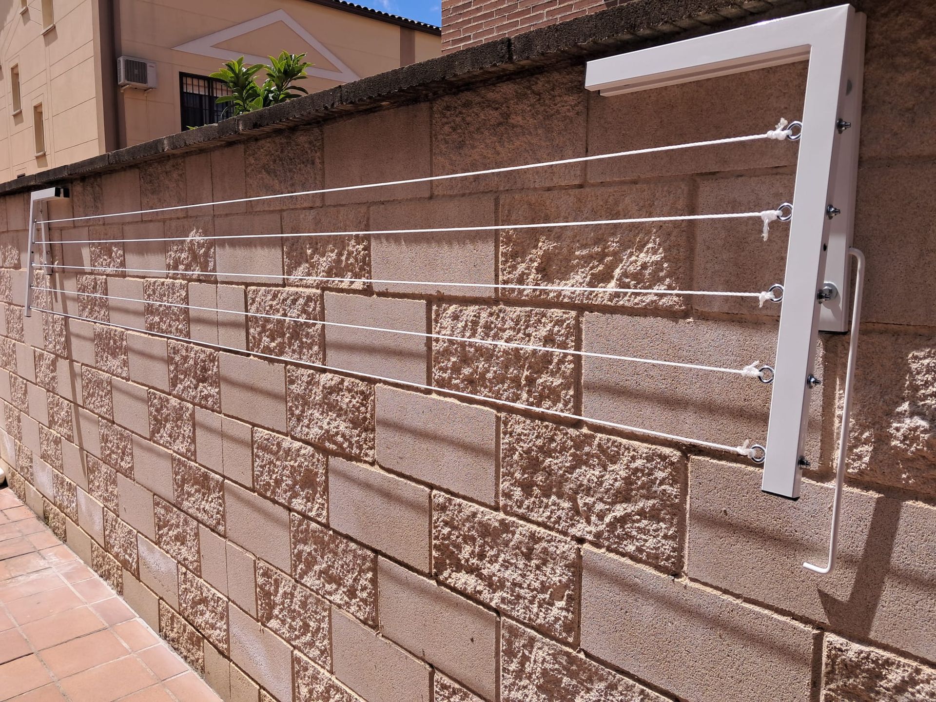 Una pared de ladrillos con un tendedero pegado a ella