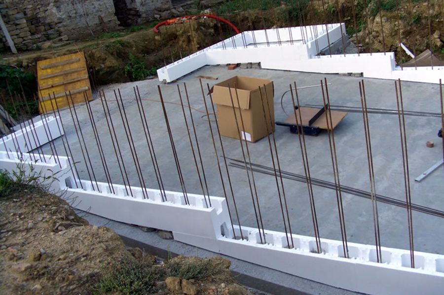 Una scatola è appoggiata a terra accanto a un muro di cemento