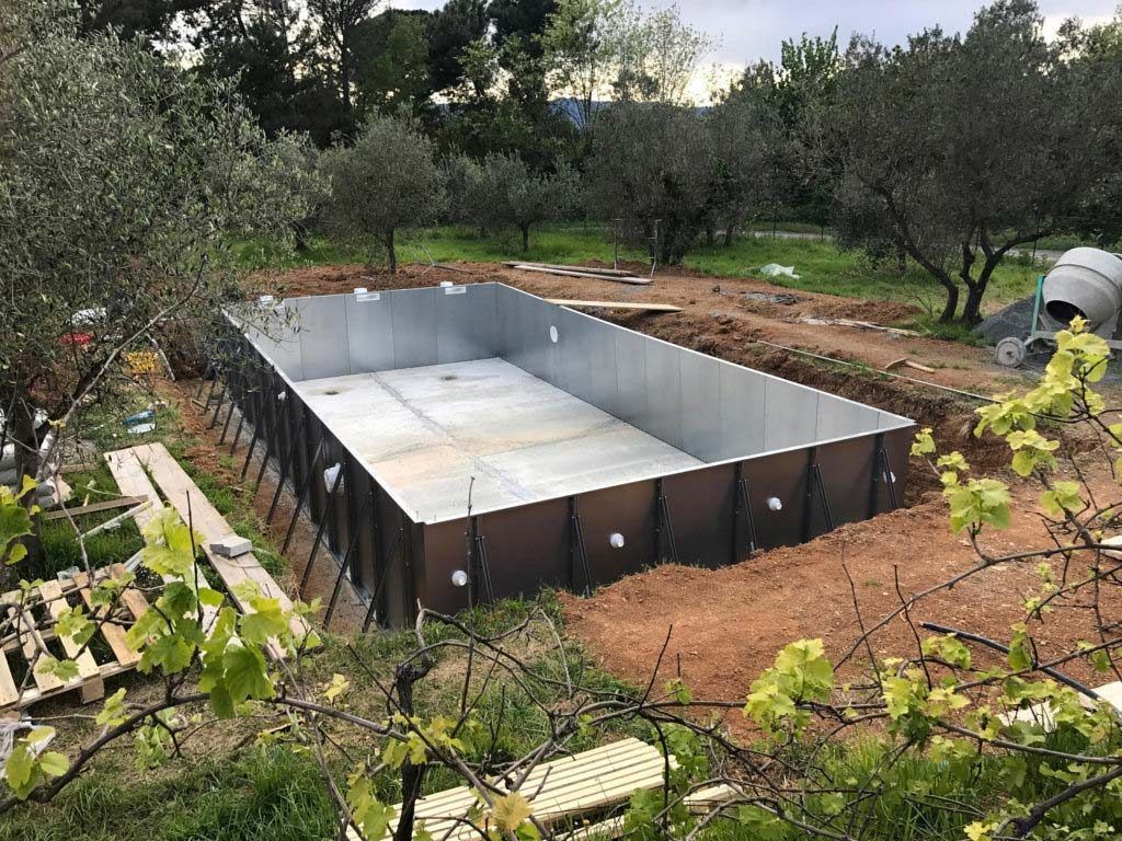 In mezzo a un campo sterrato viene costruita una grande piscina di metallo.