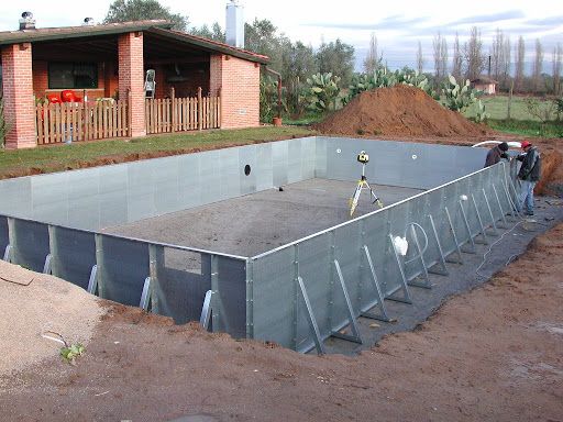 Una piscina viene costruita nel terreno davanti a una casa