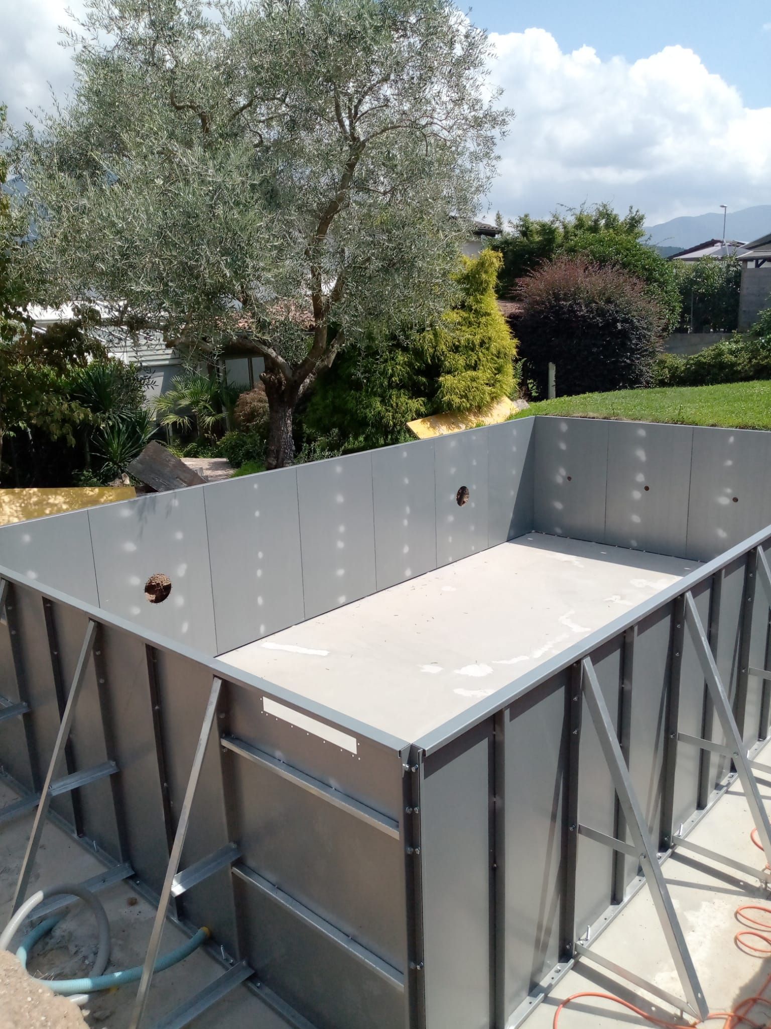 In un cortile sul retro viene costruita una grande piscina in metallo.