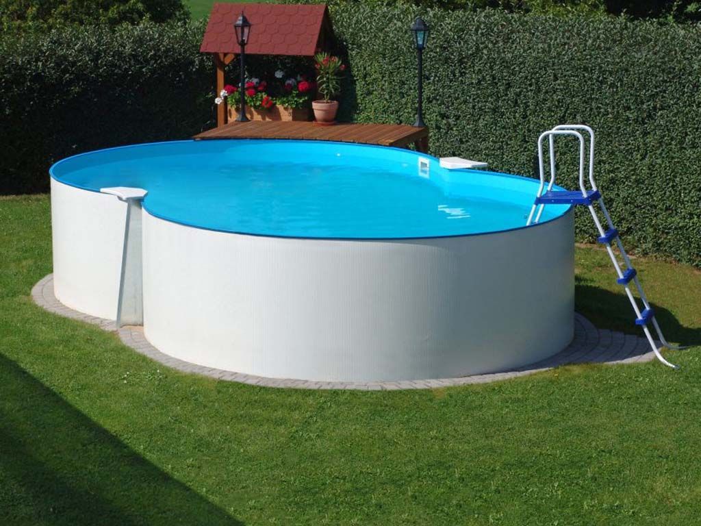 Una piscina con una scaletta attaccata si trova in cima a un rigoglioso prato verde.