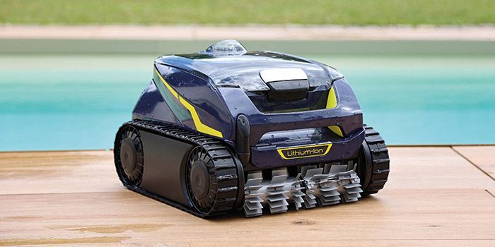 Un robot aspirapolvere è appoggiato su una terrazza di legno accanto a una piscina.