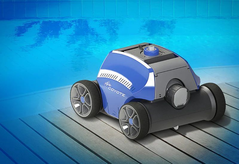 Un robot aspirapolvere è appoggiato su una terrazza di legno accanto a una piscina.