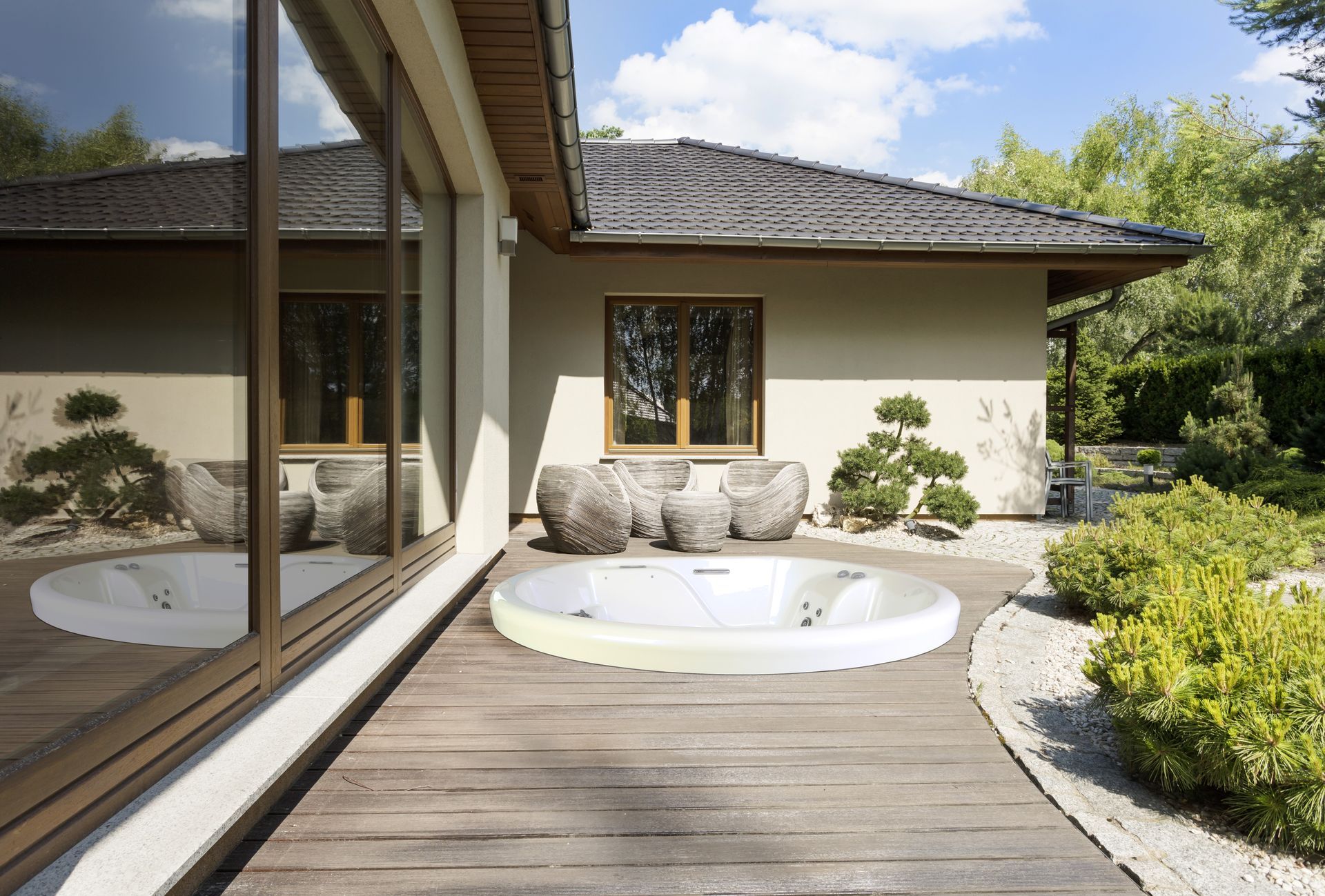 Una grande casa con una vasca idromassaggio nel cortile sul retro.