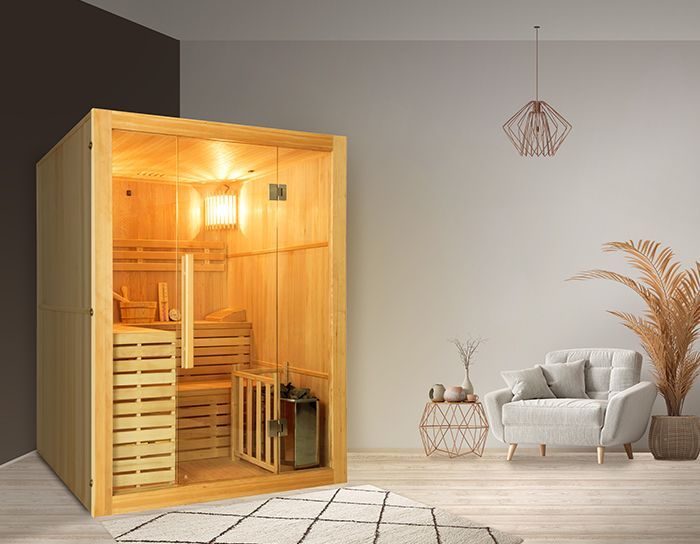 Una sauna in legno è posizionata in un soggiorno accanto a un divano e una poltrona.