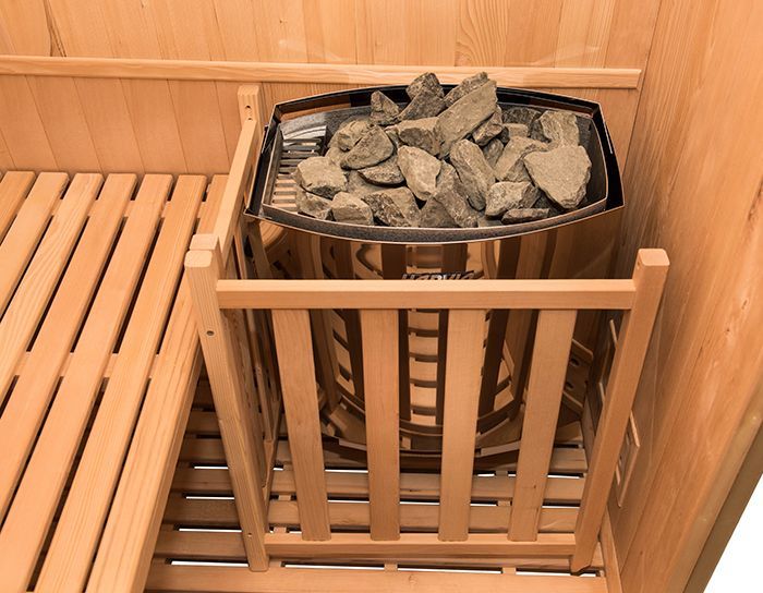 Una sauna di legno con un secchio di pietre dentro