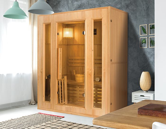 Una sauna in legno è posizionata in un soggiorno accanto a un tavolo.