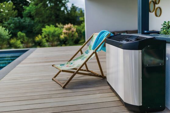 Una sedia da giardino è appoggiata su un ponte di legno accanto a una piscina.