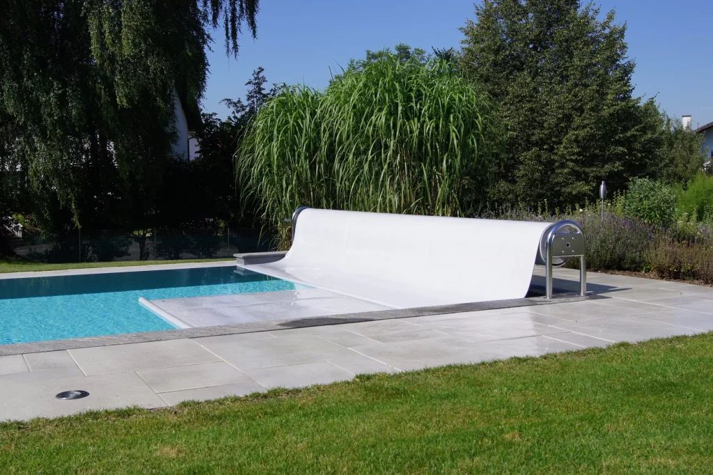 Una panchina bianca è posizionata accanto a una piscina.