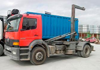 Un camión volquete rojo y azul está estacionado en un estacionamiento.