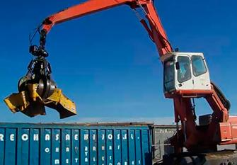 Una grúa roja y blanca está levantando un contenedor azul.