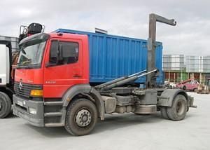 Un camión volquete rojo y azul está estacionado en un estacionamiento.