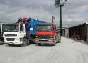 Tres camiones están estacionados uno al lado del otro en un estacionamiento.