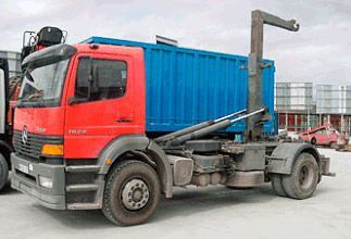 Un camión volquete rojo y azul está estacionado en un estacionamiento.