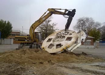 Una excavadora de gatos está cavando un hoyo en el suelo.