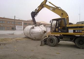 Una excavadora Cat M319 está levantando un tanque grande