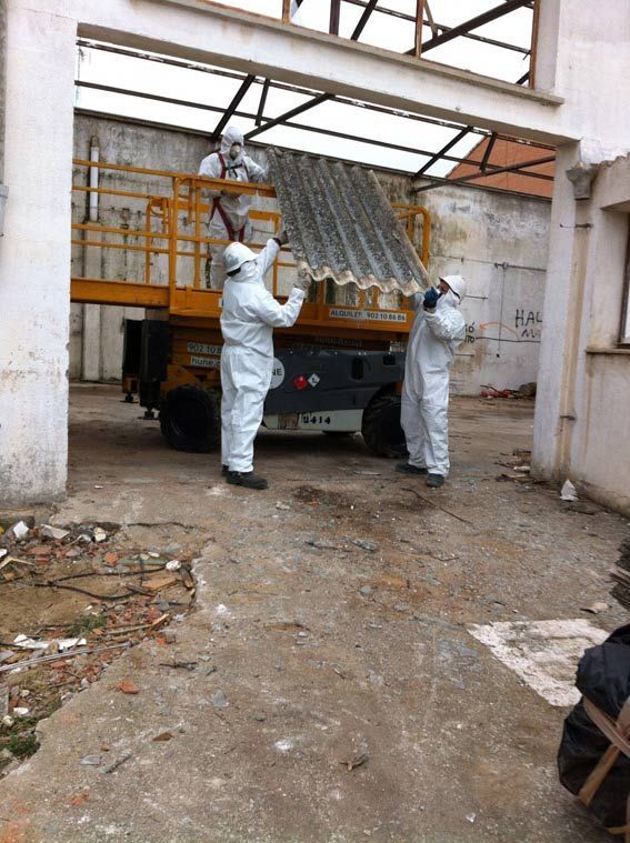 Un grupo de hombres con trajes de protección están trabajando en un edificio.