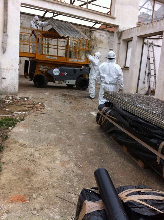 Un grupo de hombres con trajes de protección están trabajando en un edificio.