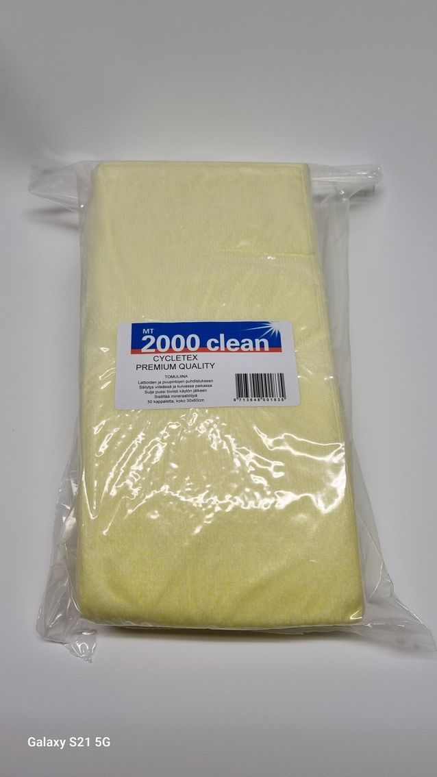 Keltainen tuotepala kirkkaassa muovipakkauksessa, jossa on mustalla tekstillä ja viivakoodilla varustettu etiketti sinivihreällä taustalla.