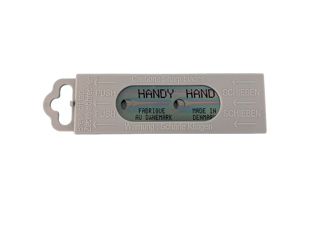 Harmaa muovirasia, jossa on kaksi partakoneen terää ja merkintä 