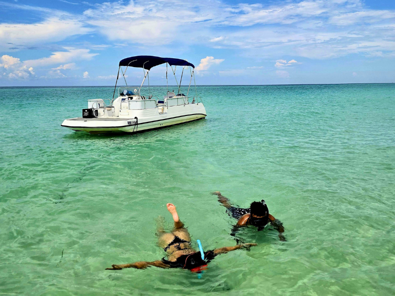 two people jumping off a boat in the florida keys