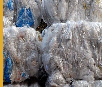 Balles compressées de sacs en plastique transparents et bleus, prêtes à être recyclées.